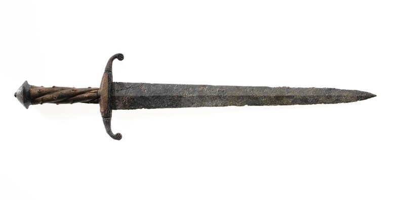 Aufnahme des Degens mit einem Holzgriff und einer Metallklinge mit Korrosionsspuren