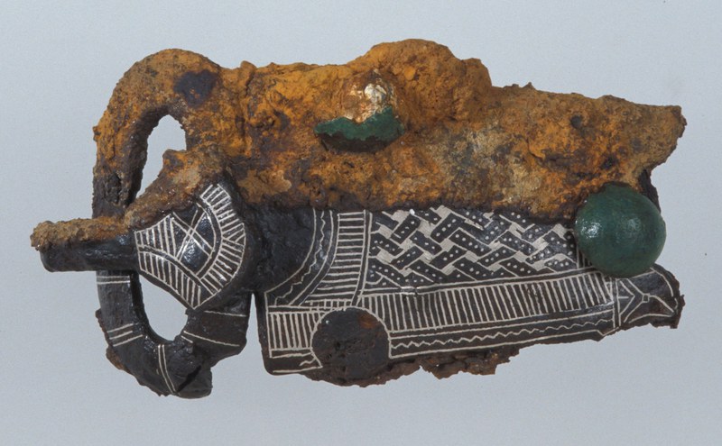 Eine halb von Korrosionen und Verkrustungen freigelegte Gürtelschnalle