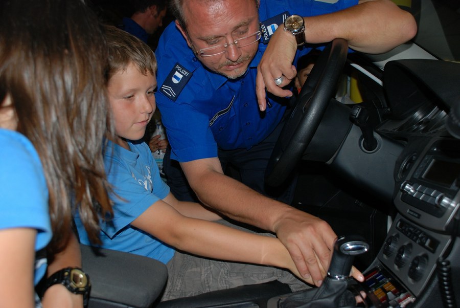 Verkehrsinstruktor Norbert Regli erklärt die Knöpfe in einem Polizeiauto